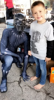 Wakandan King mascot character posing with a child at a DFW birthday party