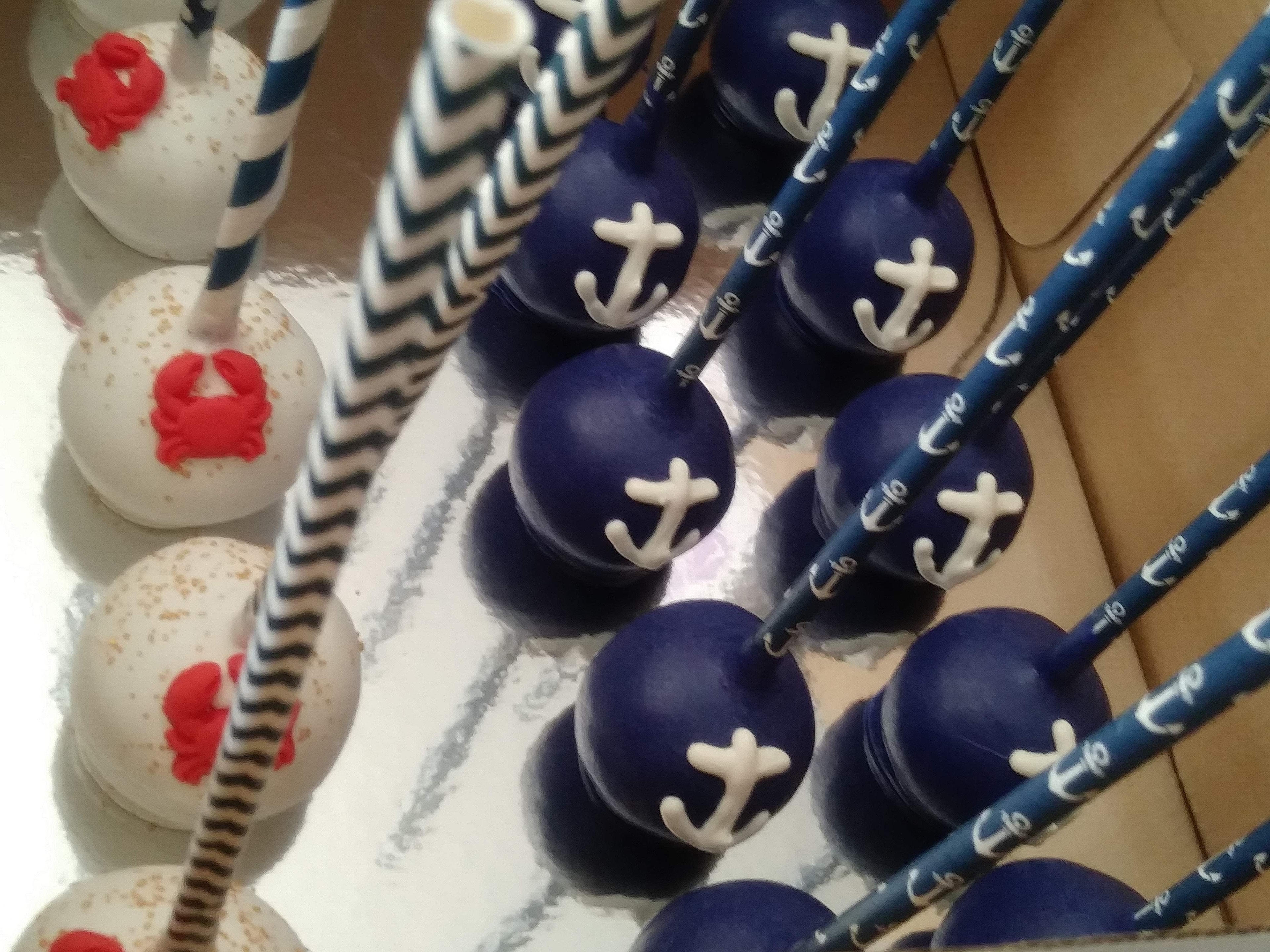 Nautical themed cake pops with blue and white sailor stripe designs on sticks