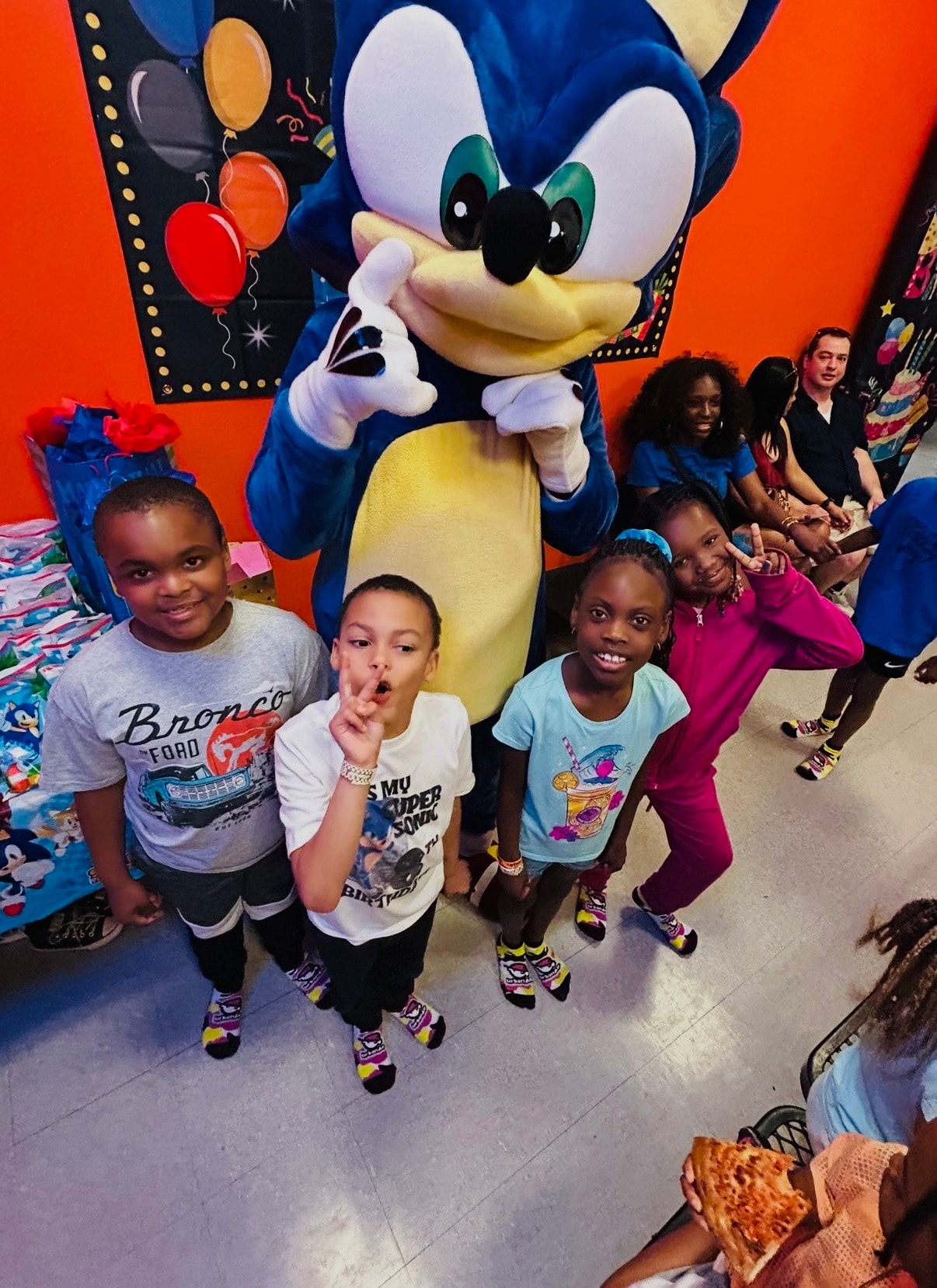 Speedy Hedgehog mascot character celebrating with children at a DFW birthday party